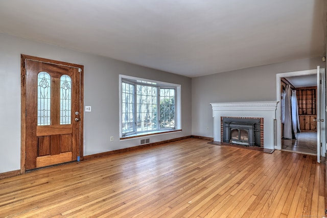 entryway featuring light wood-type flooring and a fireplace