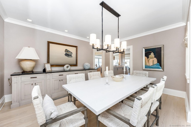 dining space with a chandelier, light wood-style flooring, crown molding, and baseboards