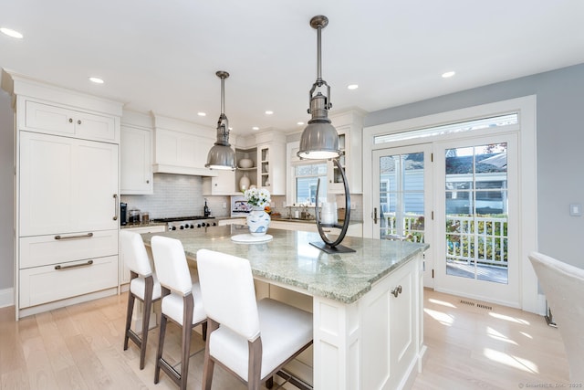 kitchen featuring tasteful backsplash, white cabinets, a center island, and open shelves