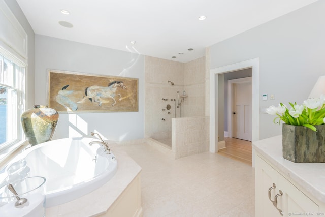 bathroom featuring a shower stall, a garden tub, recessed lighting, and a sink