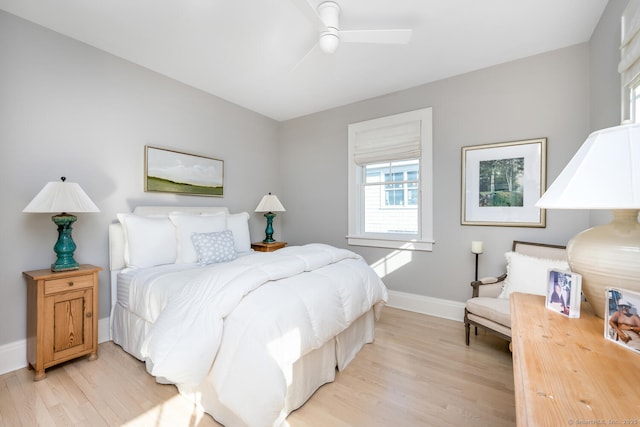 bedroom featuring light wood finished floors, a ceiling fan, and baseboards