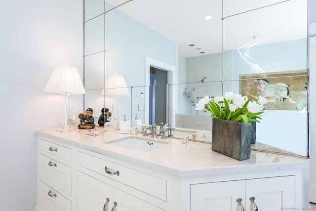 full bath with tiled shower and vanity