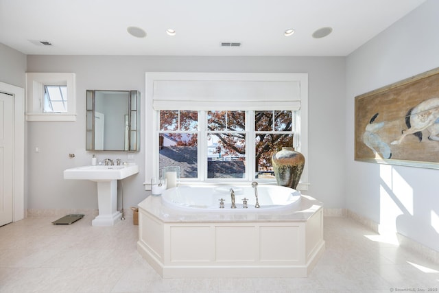 bathroom with tile patterned floors, visible vents, baseboards, and a garden tub