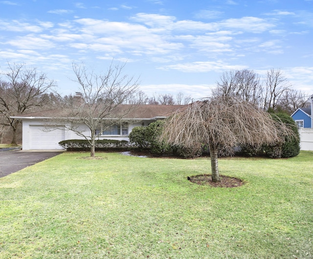 ranch-style home with a front lawn and a garage