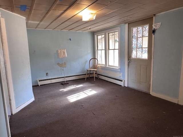 unfurnished room featuring wooden ceiling, dark carpet, and a baseboard heating unit