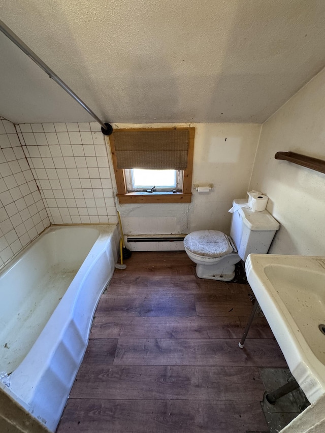 bathroom featuring toilet, baseboard heating, a textured ceiling, and hardwood / wood-style flooring