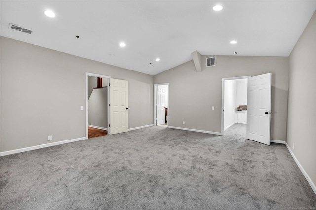 carpeted empty room with lofted ceiling