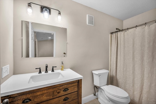 bathroom with toilet, vanity, and a textured ceiling