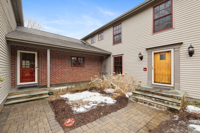 view of exterior entry with brick siding