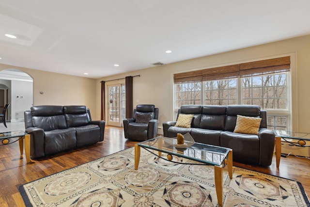 living room featuring recessed lighting, visible vents, arched walkways, and wood finished floors