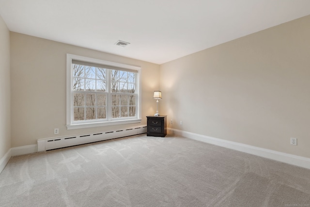 carpeted empty room with a baseboard heating unit and baseboards