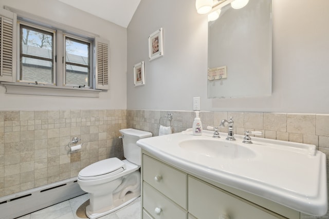 bathroom featuring toilet, a baseboard heating unit, tile walls, wainscoting, and vanity