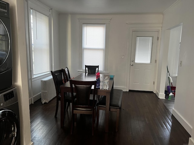 dining room with stacked washer / dryer, radiator, dark hardwood / wood-style flooring, and ornamental molding