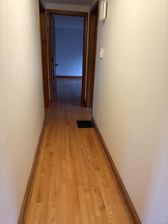 hallway featuring light wood-style floors and baseboards