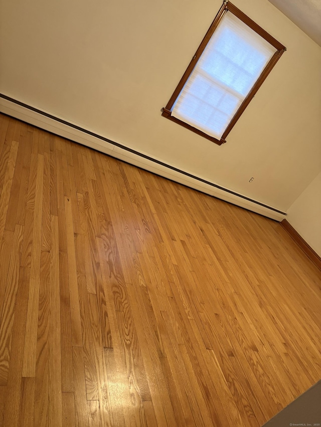 interior details featuring a baseboard heating unit and wood finished floors