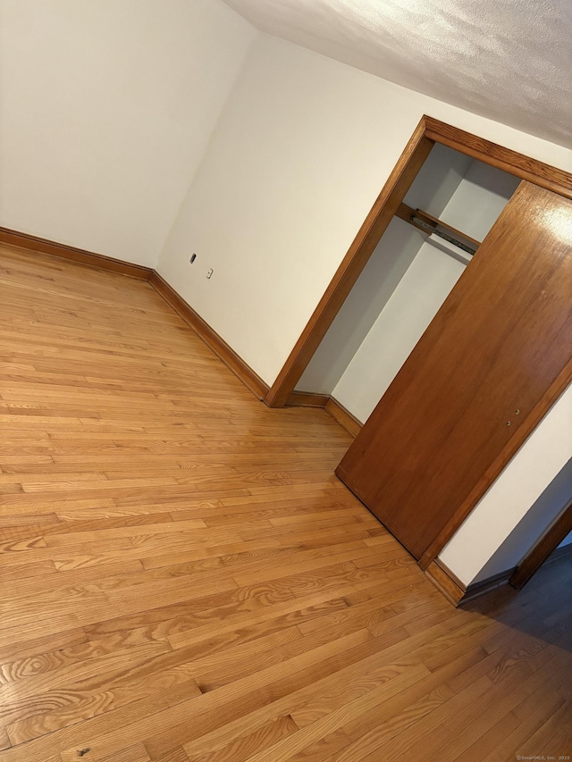 bonus room featuring light wood-style flooring and baseboards