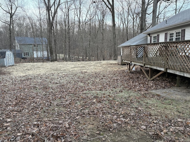 view of yard with a storage shed, an outdoor structure, and a wooden deck