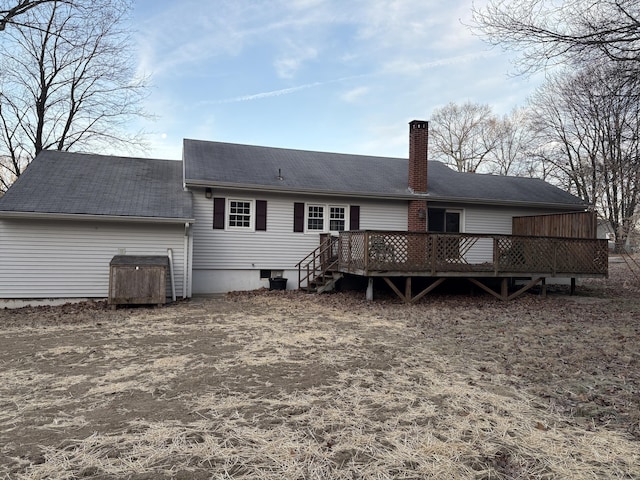 rear view of house with a chimney and a wooden deck