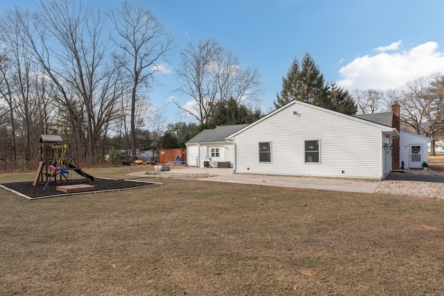 rear view of property featuring a lawn, a patio area, and a playground