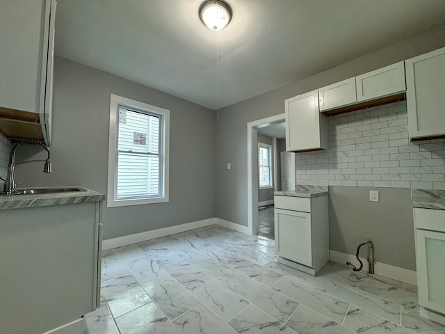 kitchen with white cabinets, tasteful backsplash, and sink