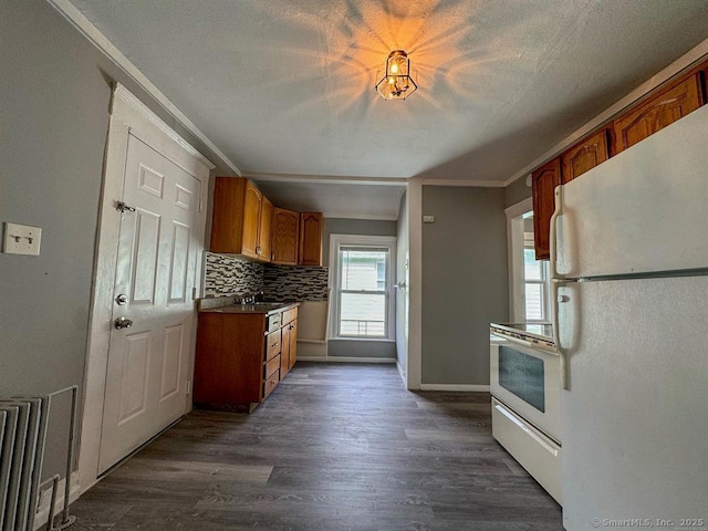 kitchen featuring white appliances, dark hardwood / wood-style floors, crown molding, and tasteful backsplash