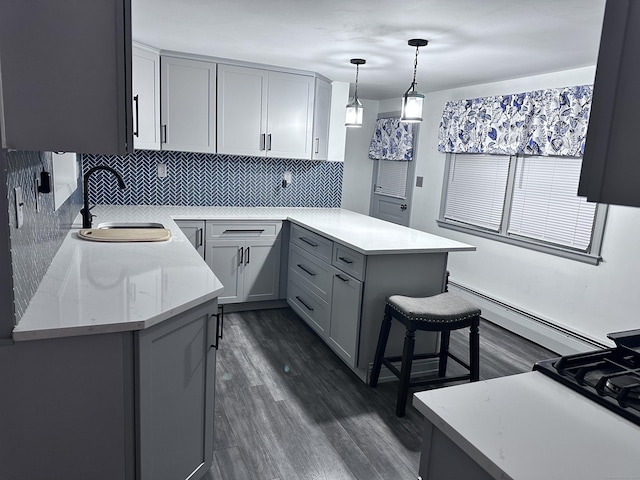 kitchen featuring gray cabinetry, tasteful backsplash, pendant lighting, light stone counters, and sink