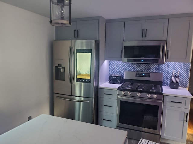 kitchen featuring tasteful backsplash, gray cabinets, and stainless steel appliances