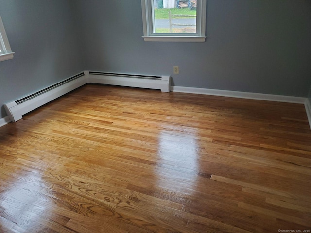 spare room with light wood-type flooring and a baseboard radiator