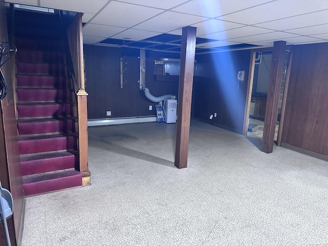 basement featuring a drop ceiling and a baseboard radiator