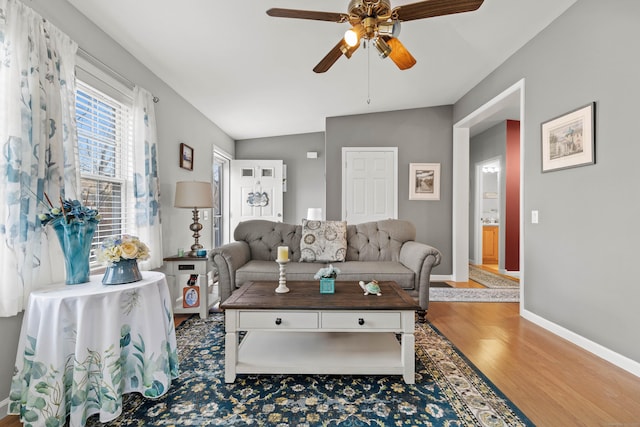 living room featuring vaulted ceiling, ceiling fan, and hardwood / wood-style flooring