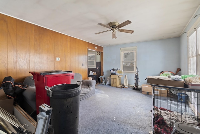 misc room featuring wood walls, carpet flooring, and ceiling fan