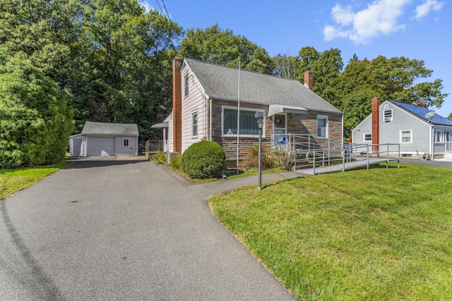 view of front of home featuring an outbuilding, a front yard, and a garage