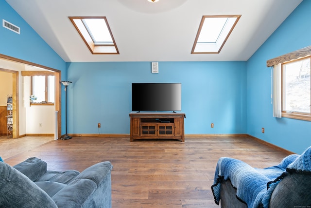 living room featuring lofted ceiling with skylight and hardwood / wood-style floors