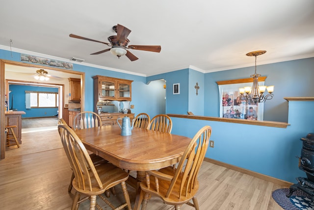 dining area featuring ornamental molding, ceiling fan with notable chandelier, and light hardwood / wood-style flooring