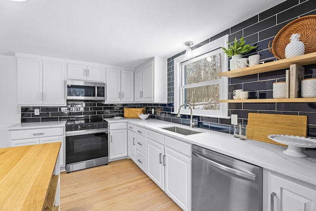 kitchen featuring white cabinetry, appliances with stainless steel finishes, sink, and decorative backsplash