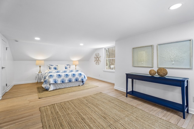 bedroom with vaulted ceiling and light hardwood / wood-style flooring