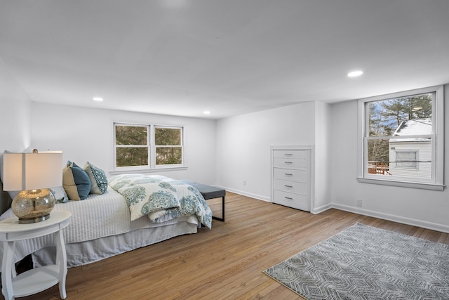 bedroom with multiple windows and light wood-type flooring