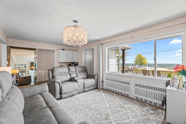 living room with radiator, a water view, and an inviting chandelier