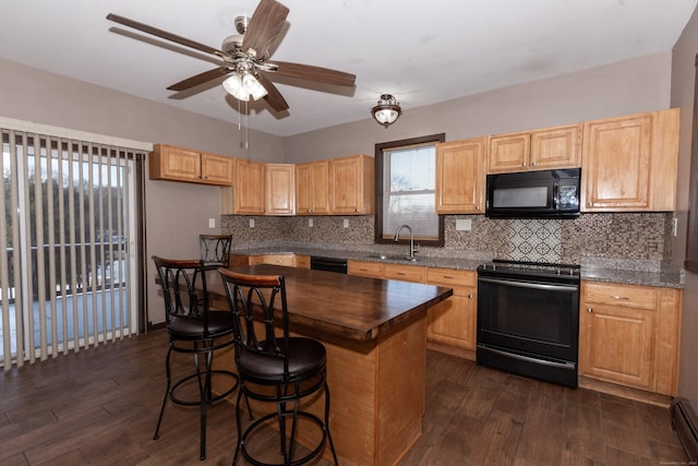 kitchen featuring sink, dark hardwood / wood-style floors, black appliances, and a center island