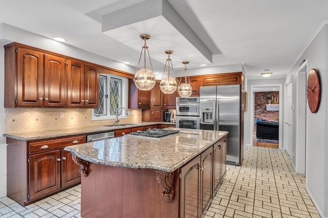 kitchen with pendant lighting, appliances with stainless steel finishes, a center island, sink, and backsplash