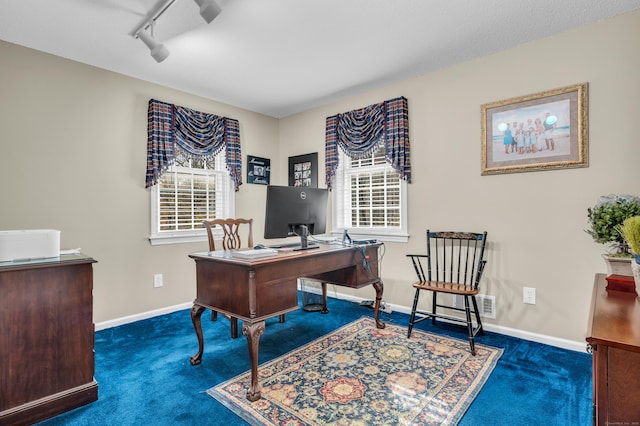 carpeted office featuring track lighting