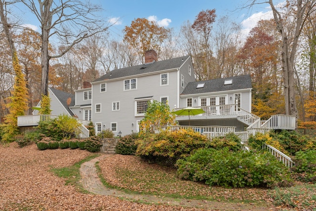 rear view of property featuring a wooden deck