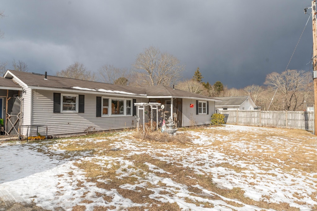 ranch-style house featuring fence