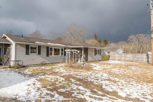 ranch-style house featuring fence