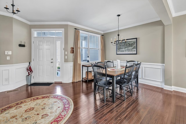 dining area featuring visible vents, a chandelier, dark wood-type flooring, and ornamental molding