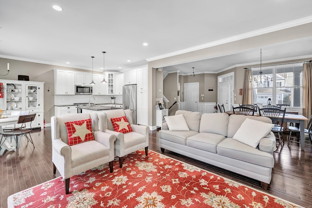 living area with stairs, recessed lighting, dark wood finished floors, and crown molding