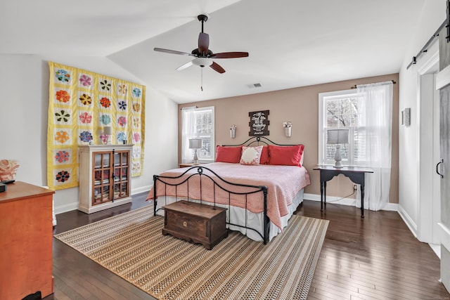 bedroom featuring lofted ceiling, visible vents, multiple windows, and hardwood / wood-style flooring