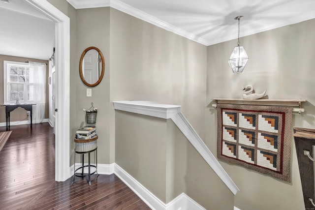 corridor featuring dark wood-style floors, ornamental molding, an upstairs landing, and baseboards