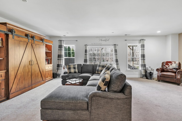 living room with a barn door, recessed lighting, light carpet, visible vents, and baseboards