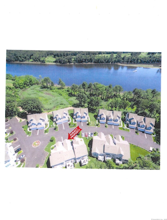 drone / aerial view with a water view, a wooded view, and a residential view